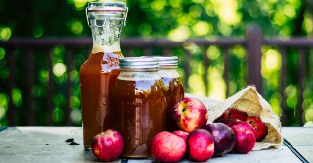 Jars that are full of cider that made out of apples.