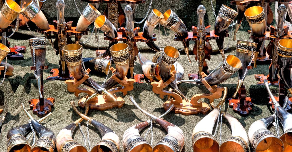 Various drinking horns with silver embellishment displayed on a table.