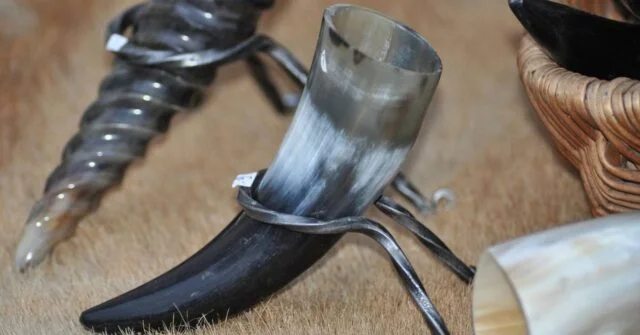 A drinking horn displayed using a special metal stand.