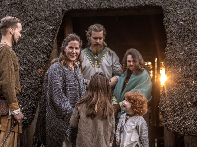 A viking family posing for picture while in a viking festival.