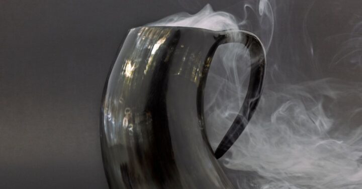 A black tankard with smoke emanating from the top indicating a hot beverage inside.