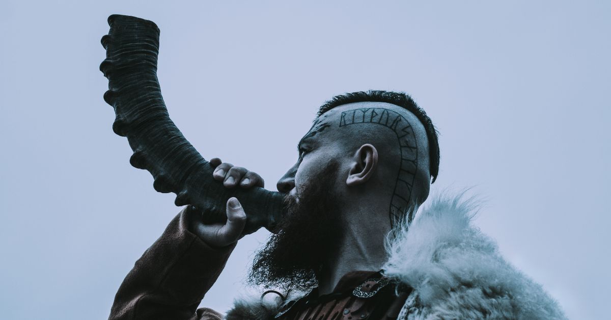 Mean looking Viking warrior blowing a war horn.